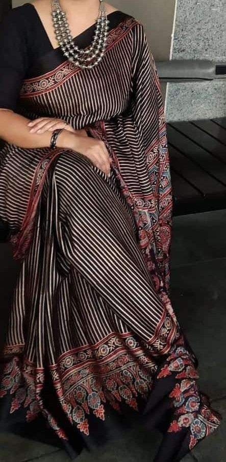 Person wearing a traditional saree with intricate patterns and designs.