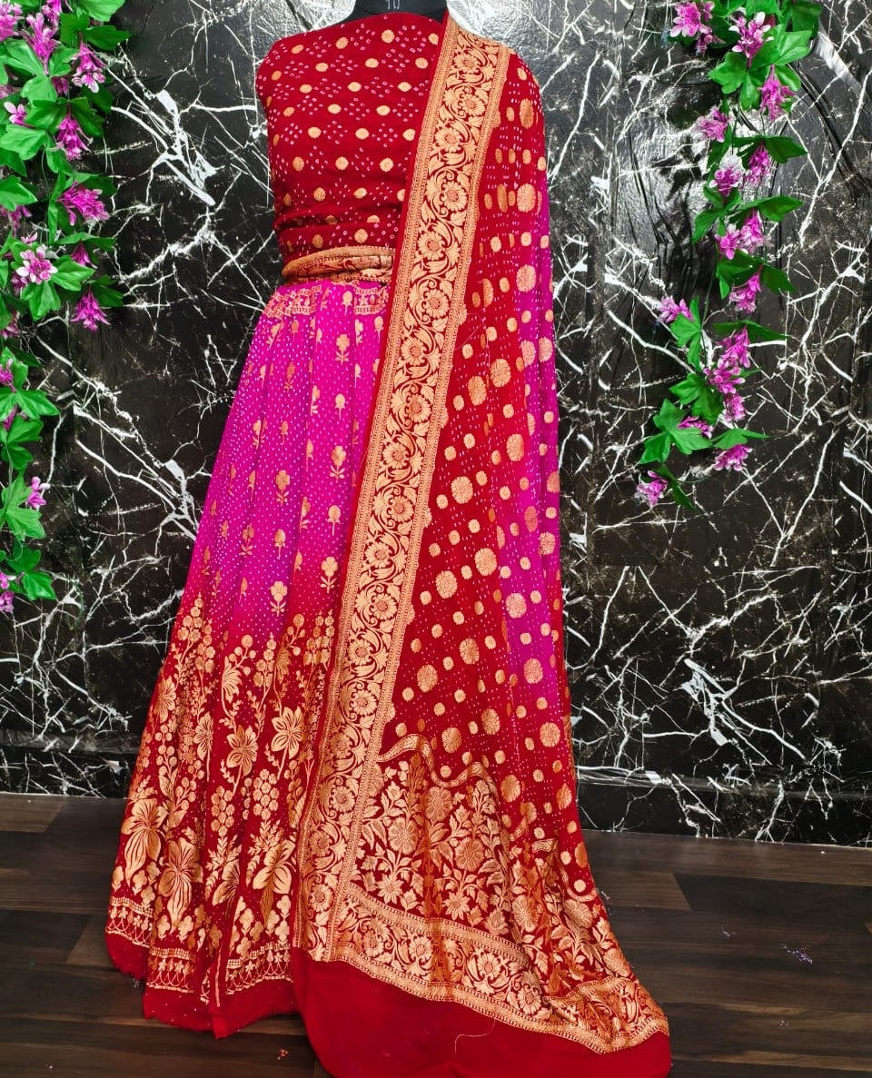 Red and pink saree with gold embroidery on a black marble background