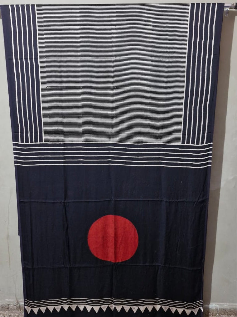 Traditional fabric with a red circle design hanging on a rod against a plain wall.