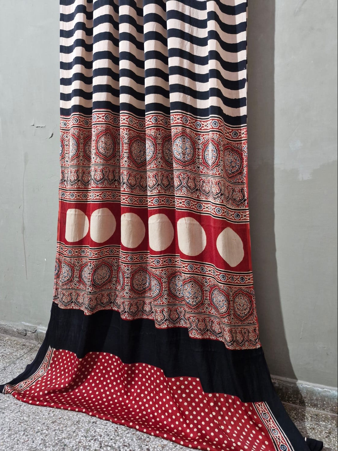 Traditional patterned fabric draped over a surface with a gray background