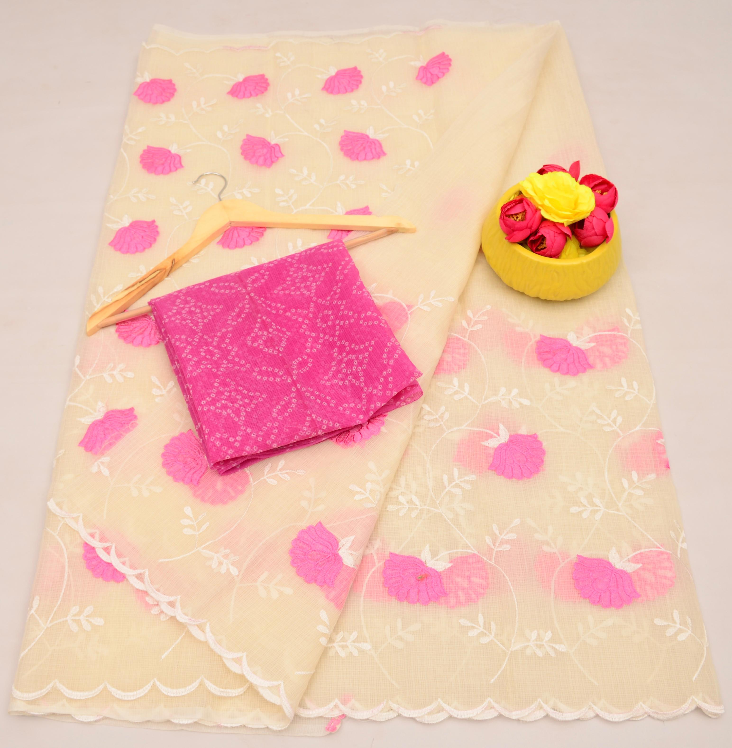 Cream fabric with pink floral patterns, a wooden hanger, and a yellow container with pink flowers on a beige background.