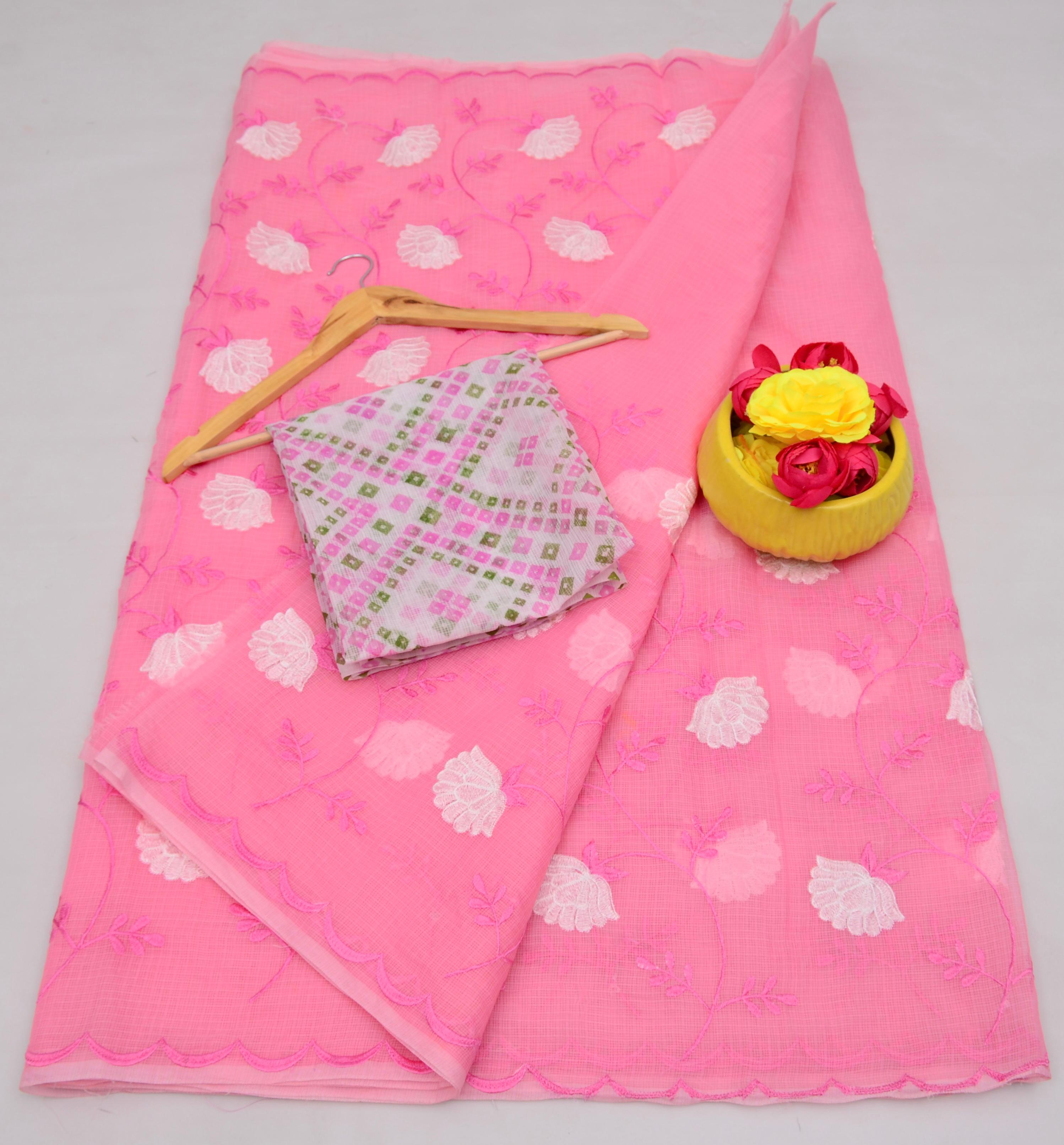 Light Pink fabric with floral patterns, a folded fabric piece, and a yellow basket with flowers on a gray background.