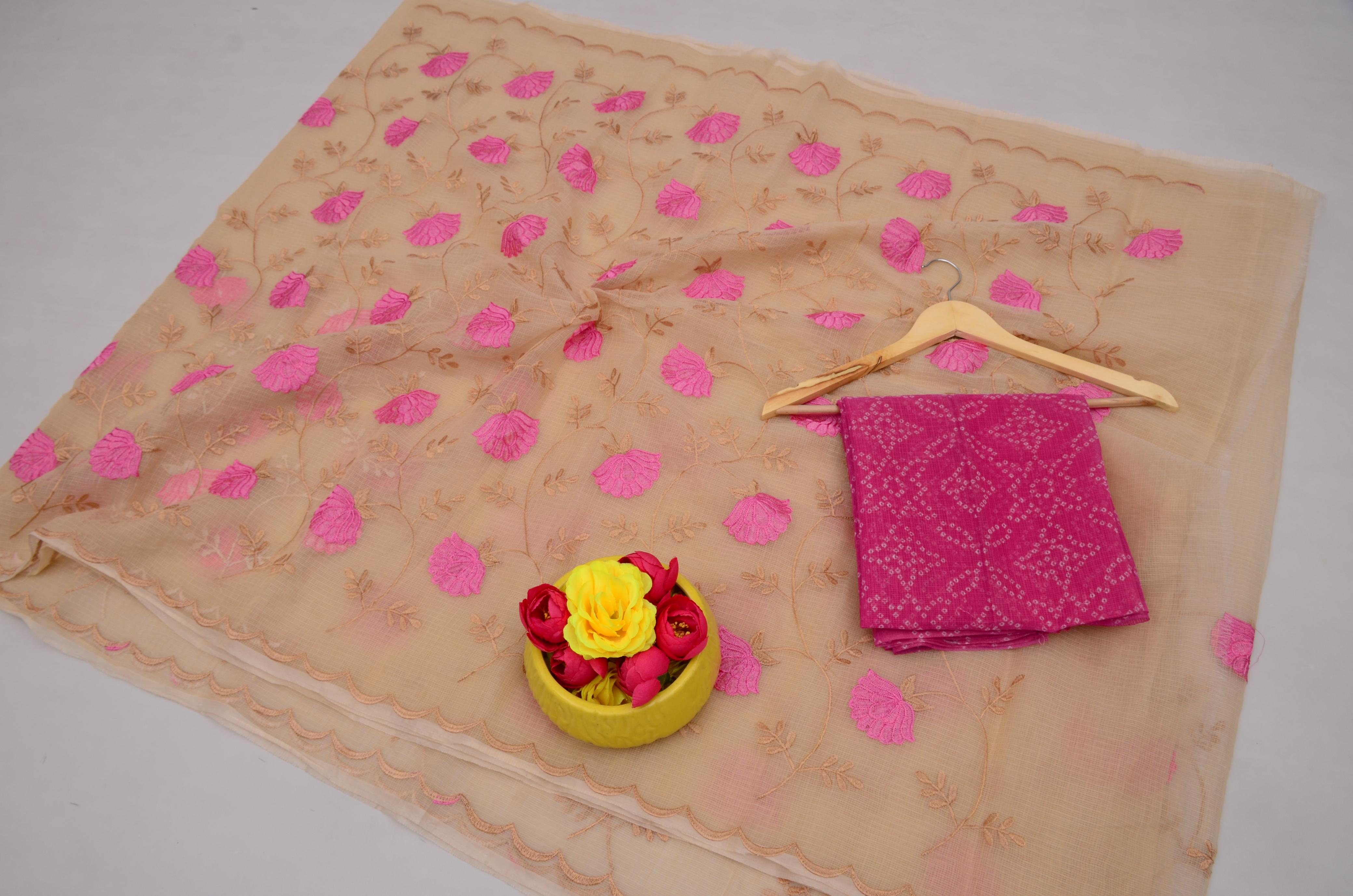 Beige fabric with pink floral patterns, a pink folded fabric, a yellow bowl with flowers, and a wooden hanger on a white background.