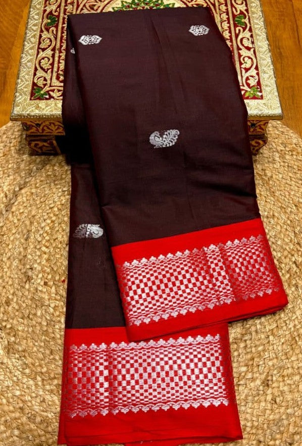 Brown and red saree with white patterns on a textured surface