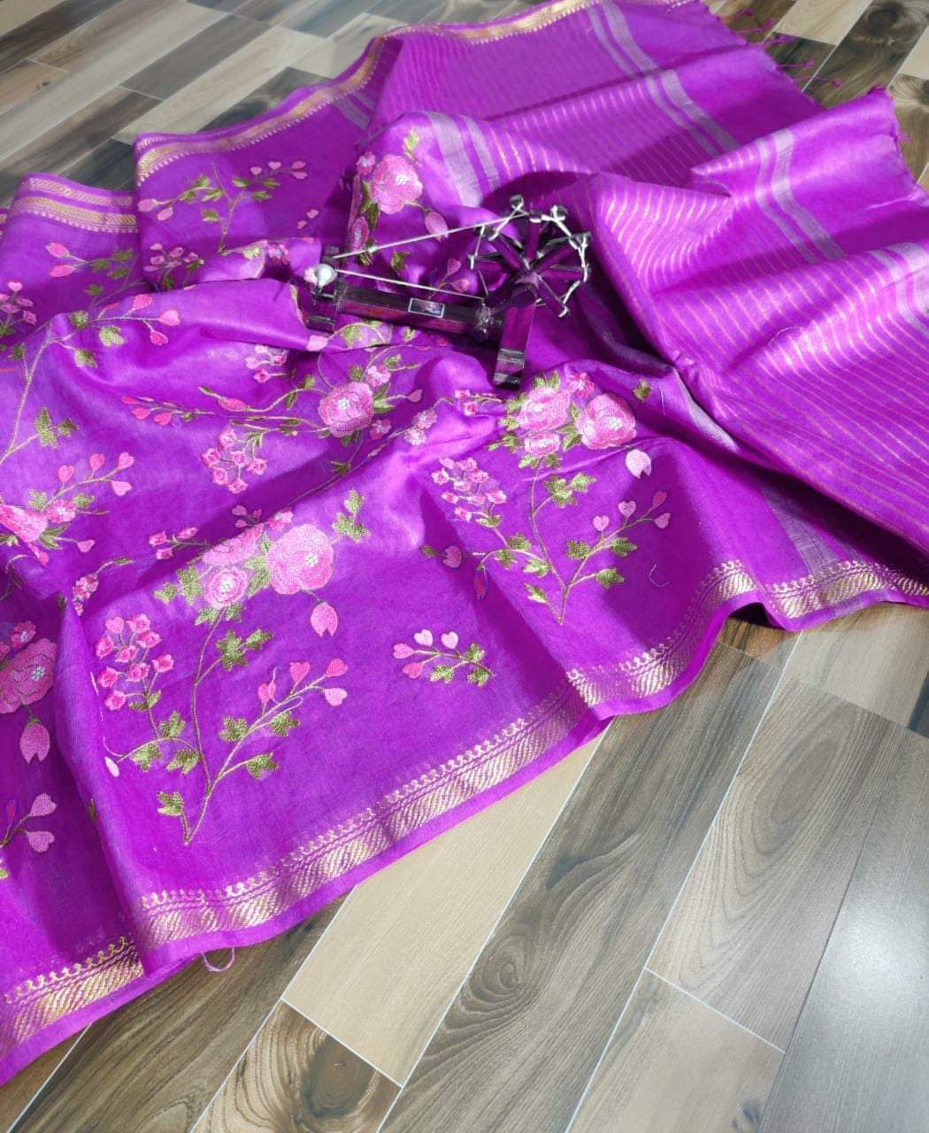 Purple saree with floral patterns on a wooden floor