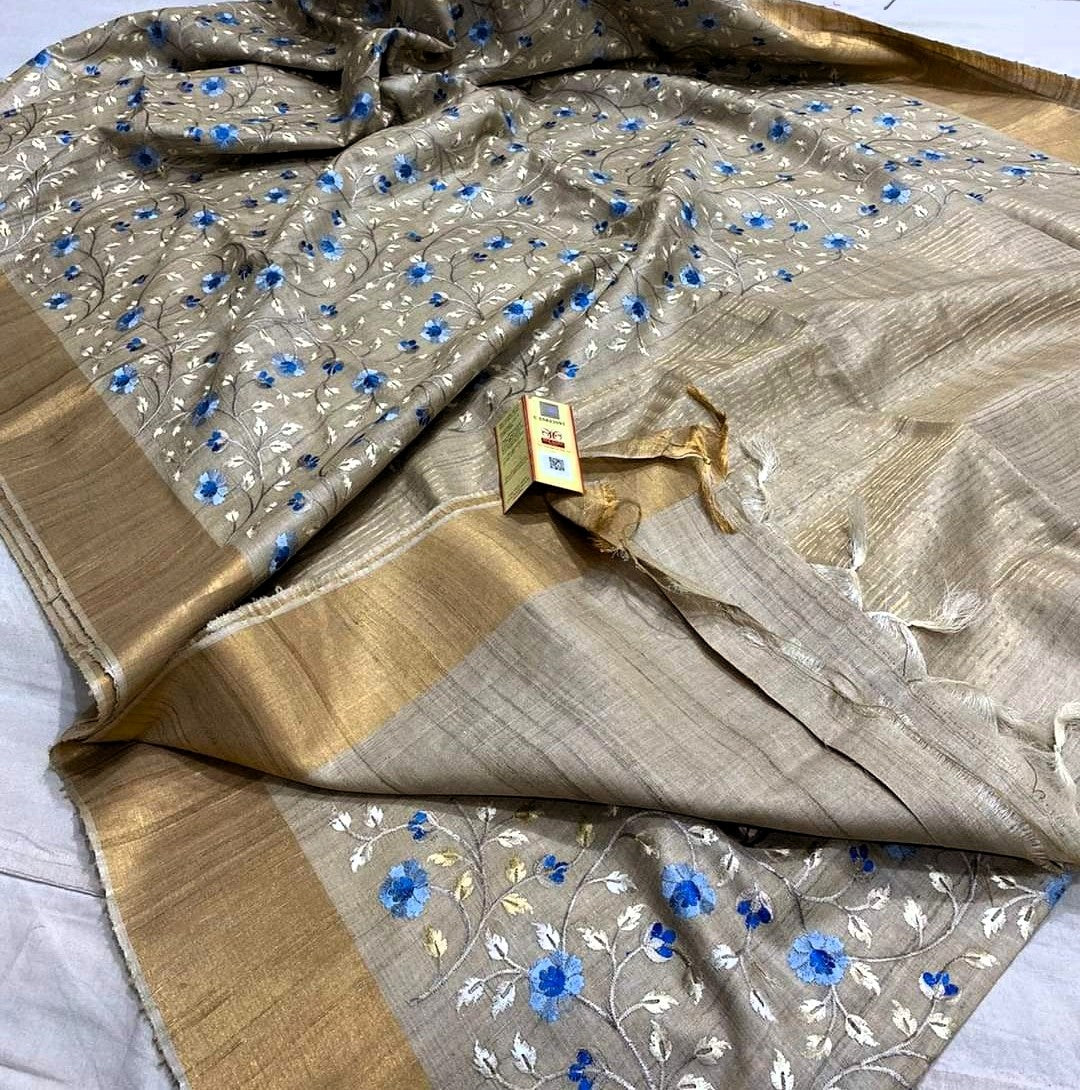 Folded saree with floral patterns and gold border on a white background