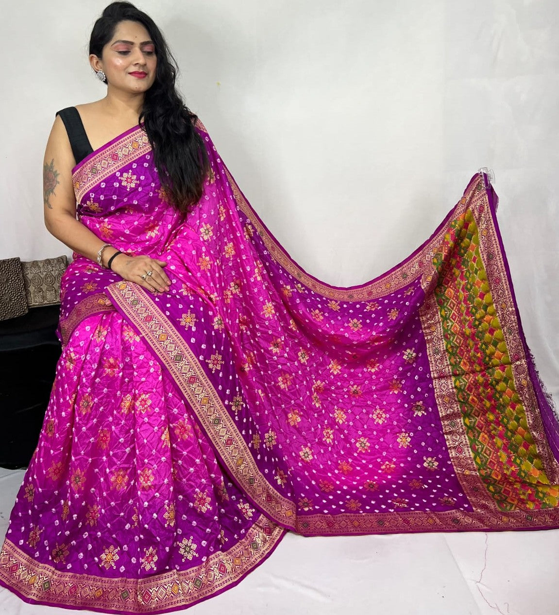 Woman wearing a vibrant pink saree with floral patterns on a white background