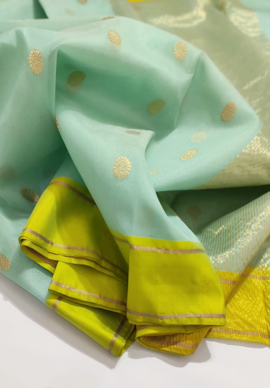 Light green fabric with gold patterns on a white background