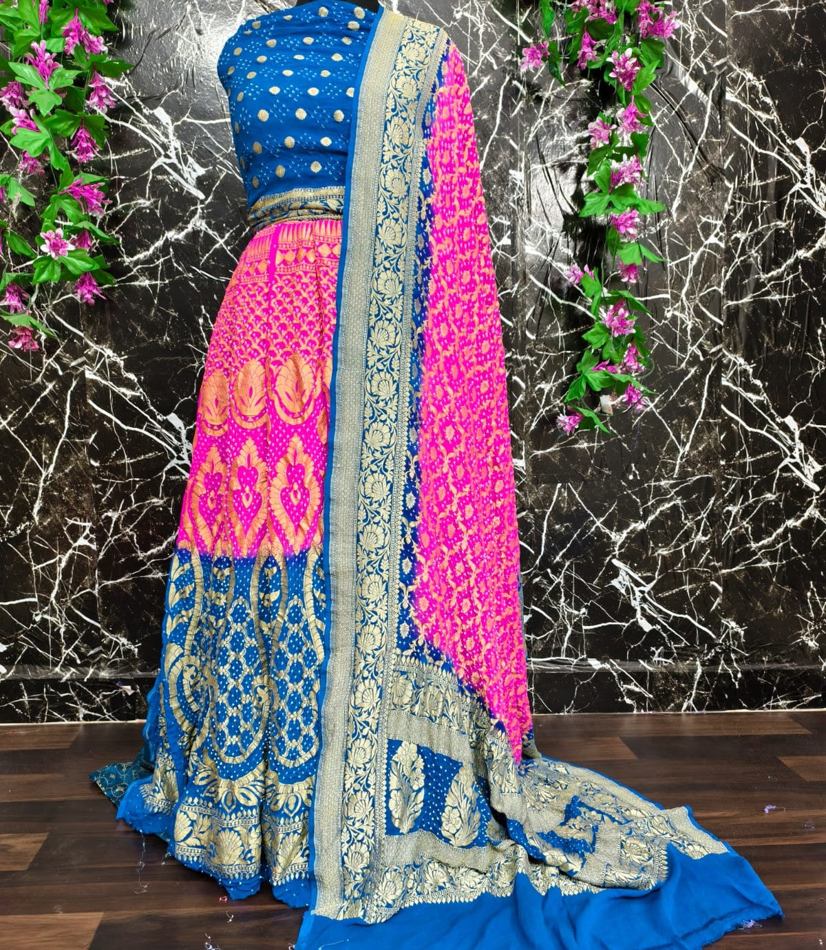 Traditional blue and pink saree with floral decorations on a marble background
