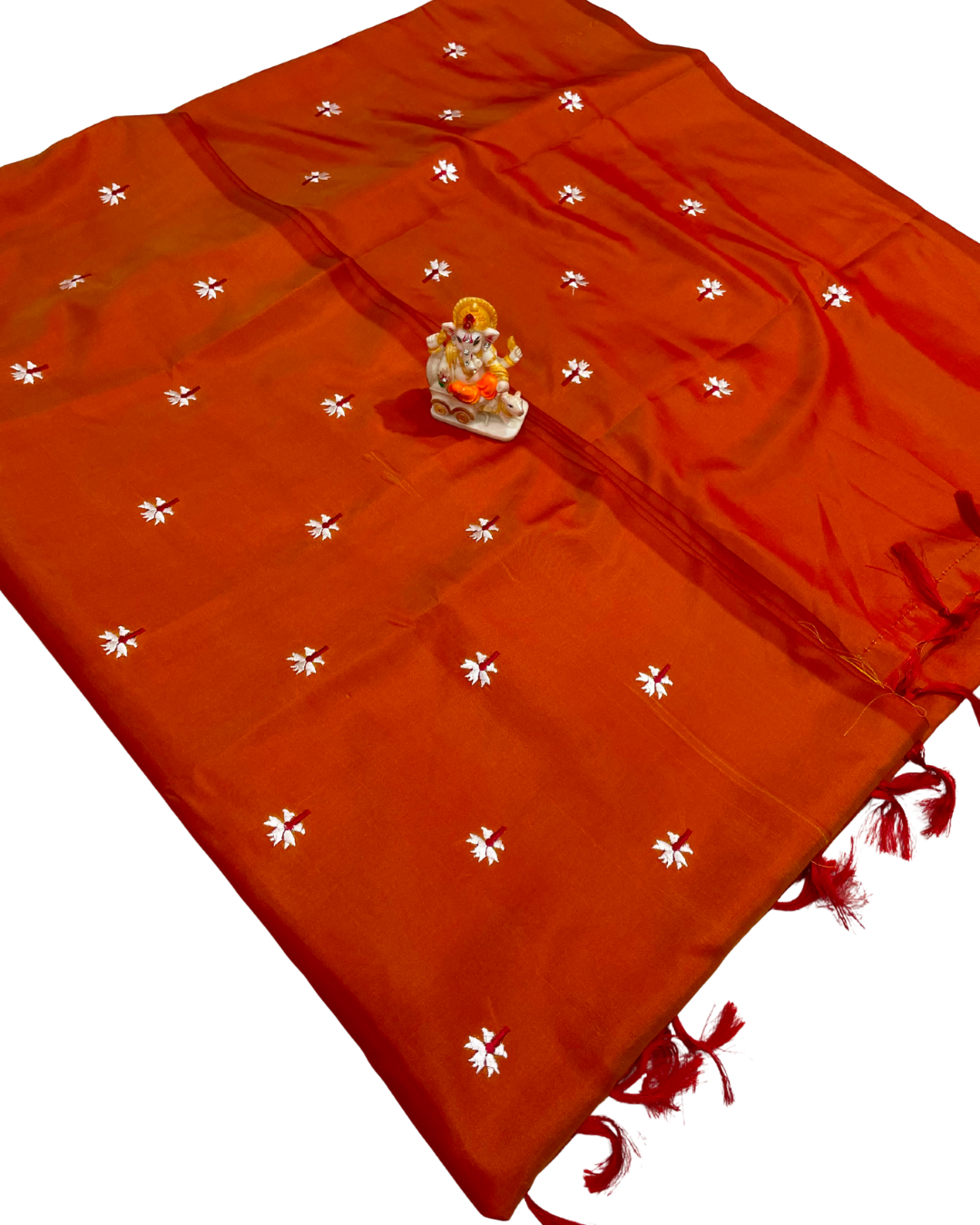 Orange saree with white floral patterns and a small deity figure on a white background