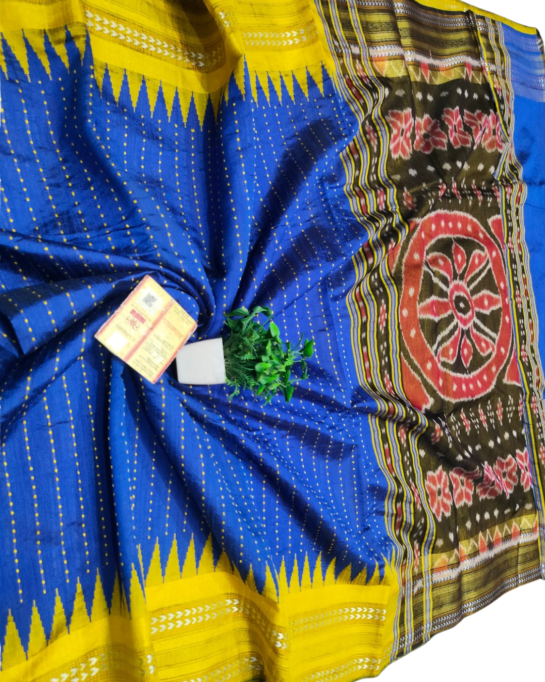 Colorful traditional fabric with blue, yellow, and multicolor patterns on a white background