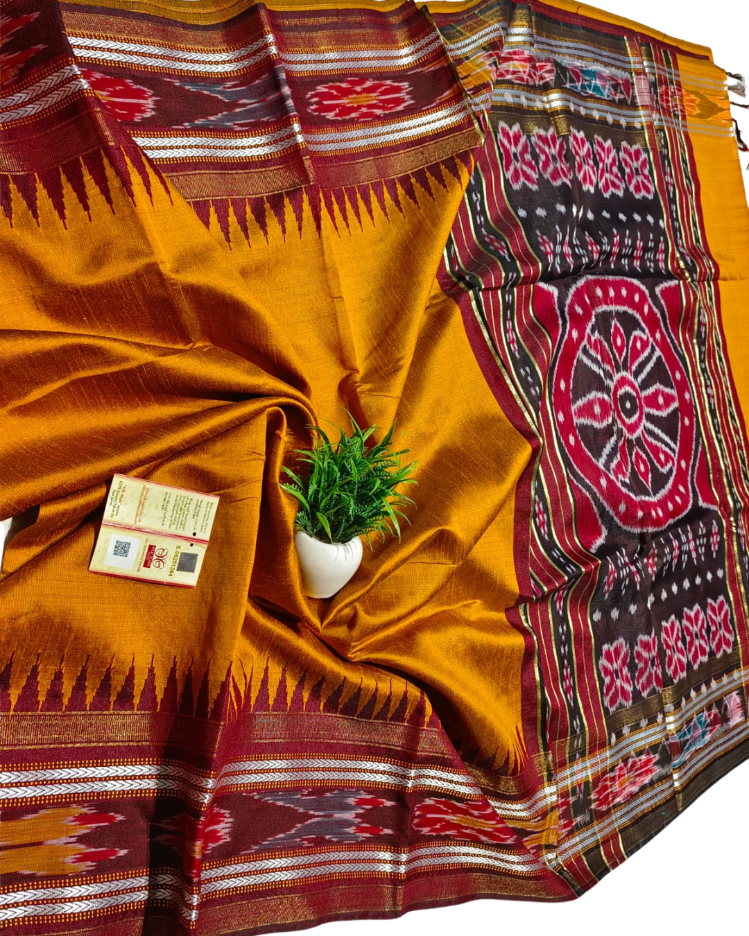 Traditional fabric with intricate patterns and a small plant in the center.