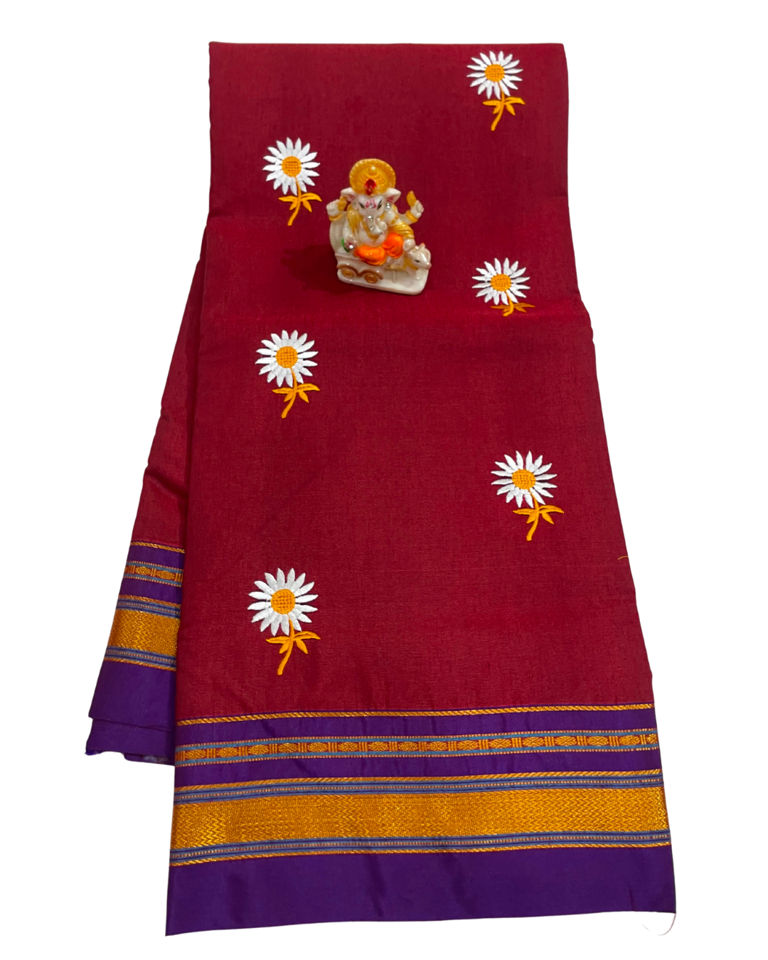 Red fabric with white flowers and a small statue on a white background