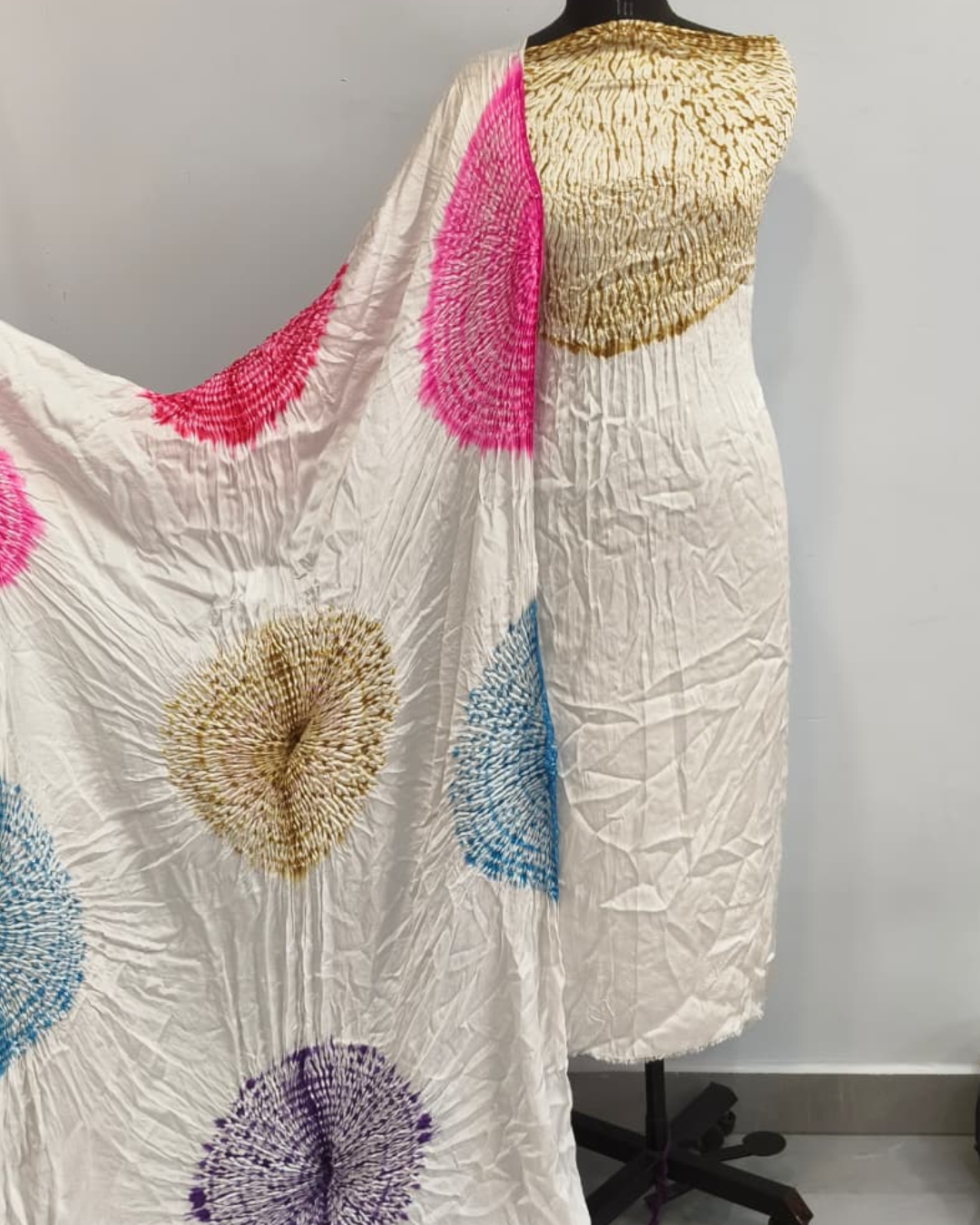 white Dress with colorful circular patterns on a mannequin against a plain background