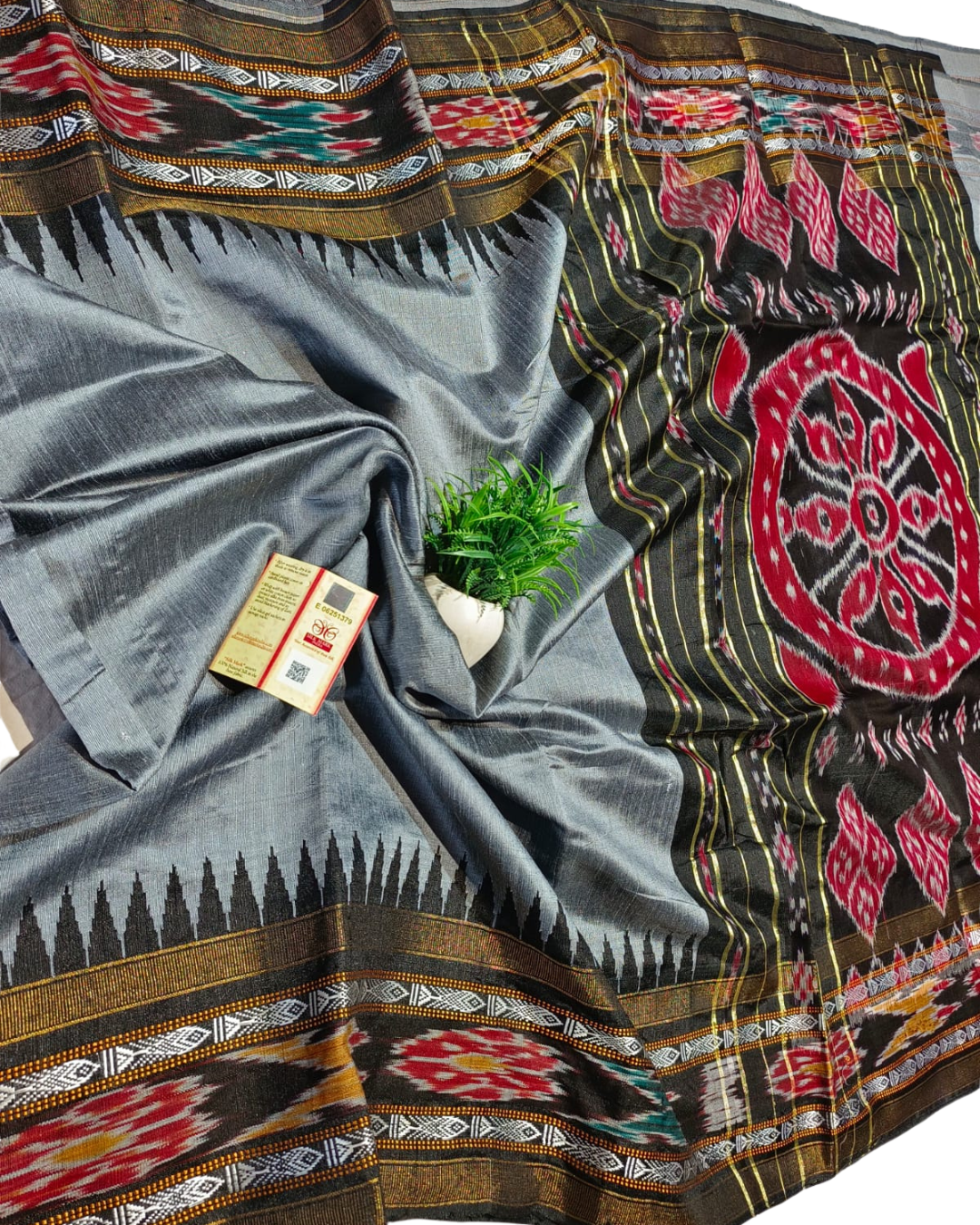 Gray fabric with colorful geometric patterns and a small plant on a white background