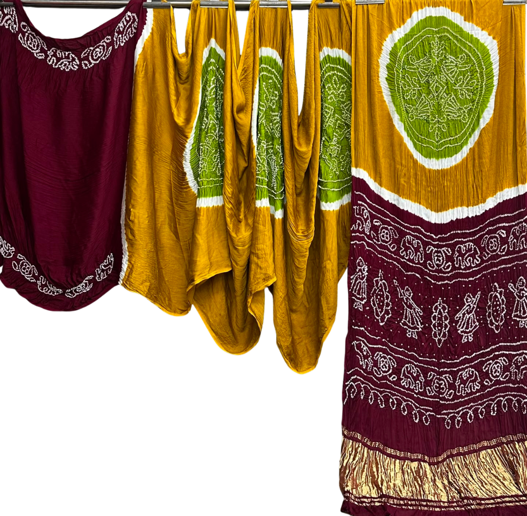 Three bohemian-style fabric garments or shawls in maroon, mustard yellow, and green tie-dye patterns with white embroidery, displayed against a solid white background.