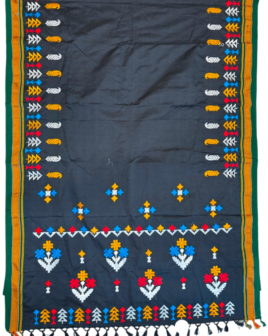 A dark charcoal gray or black traditional textile, likely a saree, featuring colorful geometric and floral patterns along the borders and a decorative horizontal band near the bottom.
