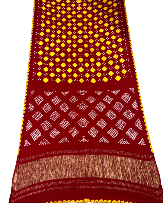 A red and yellow hand-block printed fabric, likely a saree or scarf, featuring a yellow diamond pattern on the upper section, white diamond patterns on the lower section, and a gold-toned metallic border with tassels.